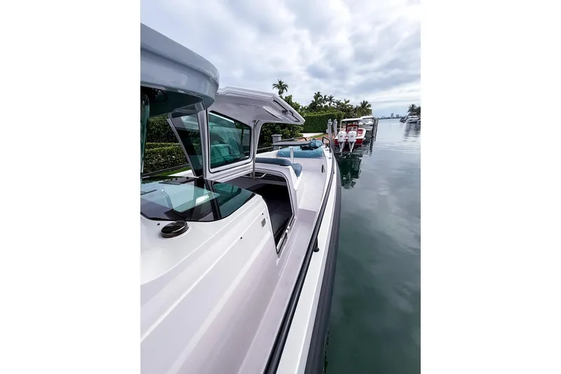  Yacht Photos Pics 2023 Axopar 37 XC Cross Cabin docked on a calm waterfront.