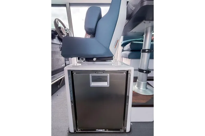  Yacht Photos Pics 2023 Axopar 37 XC Cross Cabin interior with seat and compact refrigerator.