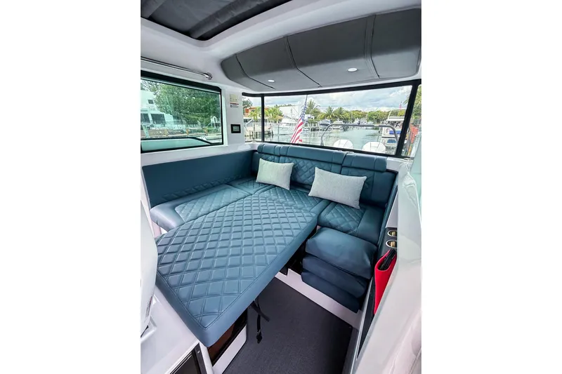  Yacht Photos Pics 2023 Axopar 37 XC Cross Cabin interior with blue quilted seating and cushions.