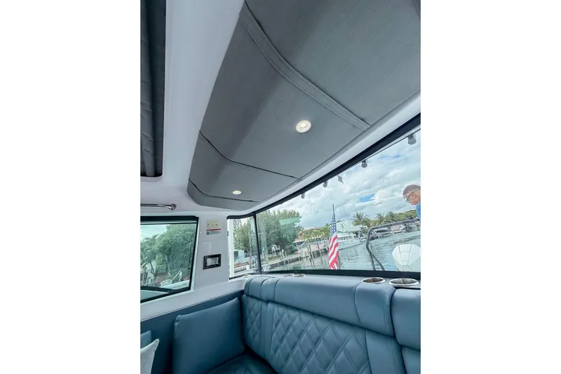  Yacht Photos Pics Interior view of 2023 Axopar 37 XC Cross Cabin with quilted seating and window view.