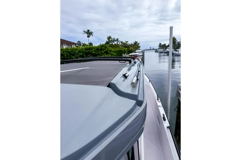  Yacht Photos Pics 2023 Axopar 37 XC Cross Cabin docked by a serene waterfront.