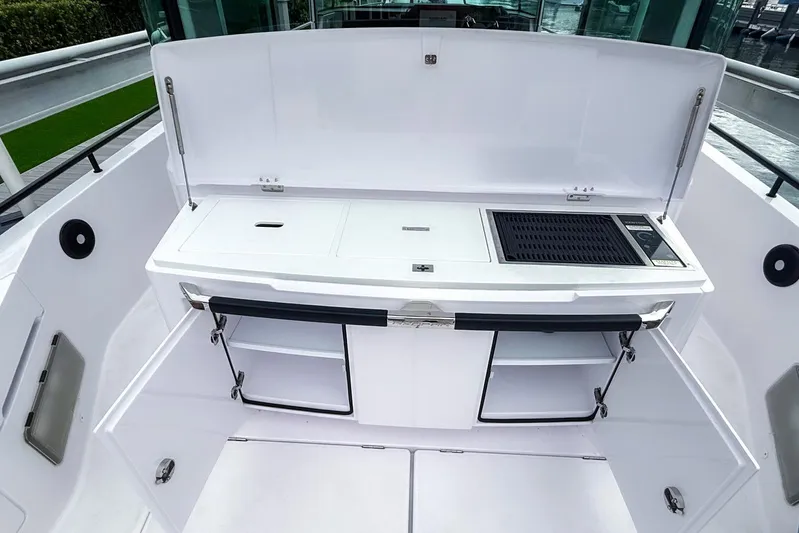  Yacht Photos Pics Outdoor kitchen on 2023 Axopar 37 XC Cross Cabin boat, featuring grill and storage compartments.