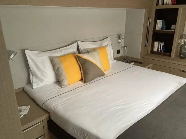  Yacht Photos Pics Luxurious bedroom interior in 2024 Lagoon SIXTY 5 yacht with modern decor and cozy bedding.