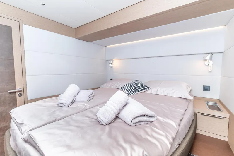  Yacht Photos Pics Luxurious bedroom interior of 2024 Lagoon SIXTY 5 yacht with neatly arranged towels.