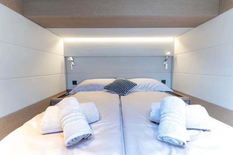  Yacht Photos Pics Luxurious bedroom interior of 2024 Lagoon SIXTY 5 yacht with neatly arranged towels.
