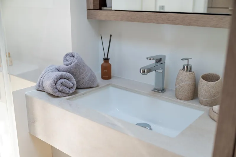  Yacht Photos Pics Luxury bathroom sink in 2024 Lagoon SIXTY 5 yacht with towels and toiletries.