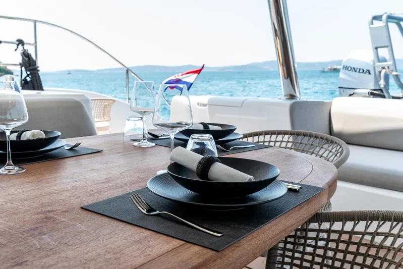  Yacht Photos Pics Elegant dining setup on 2024 Lagoon SIXTY 5 yacht with ocean view.