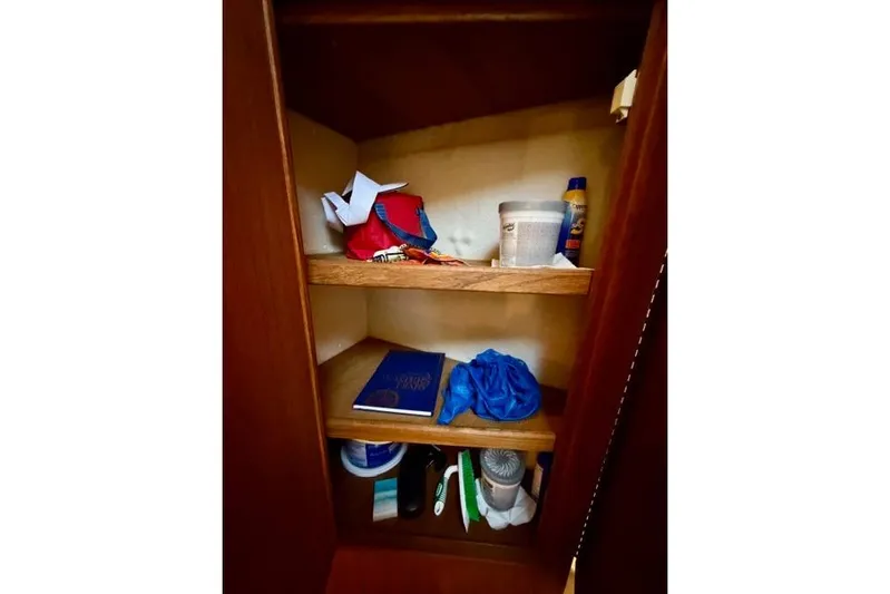  Yacht Photos Pics 2012 Ranger Tugs R-29 storage cabinet with assorted items on wooden shelves.