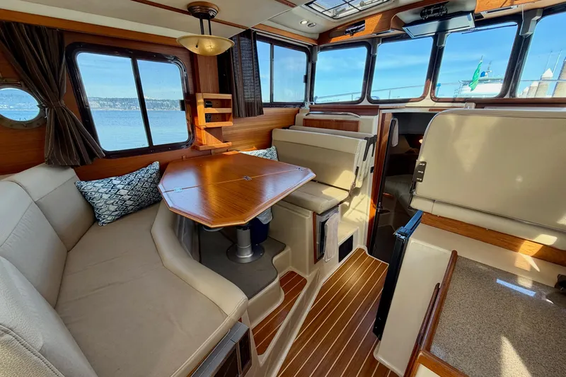  Yacht Photos Pics Interior of 2012 Ranger Tugs R-29 boat with cozy seating and wooden table.