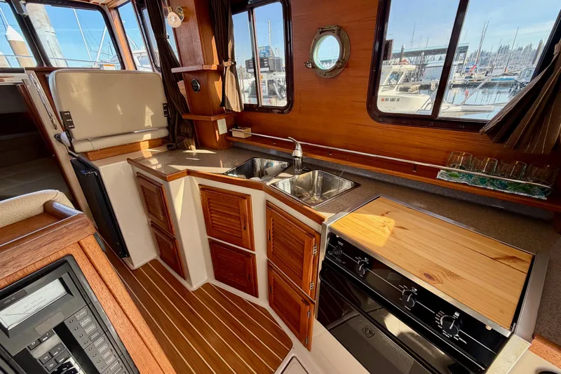  Yacht Photos Pics Interior of 2012 Ranger Tugs R-29 boat with wooden cabinetry and kitchen amenities.