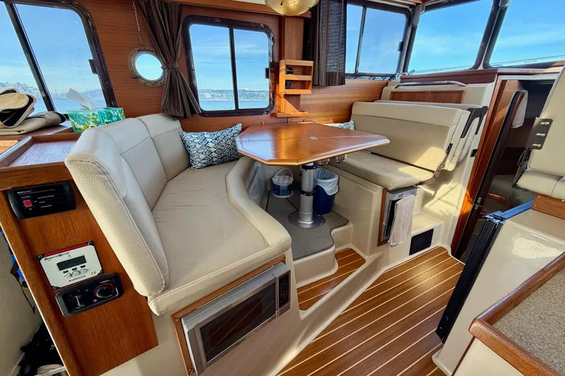  Yacht Photos Pics Interior of 2012 Ranger Tugs R-29 boat with cozy seating and wooden accents.