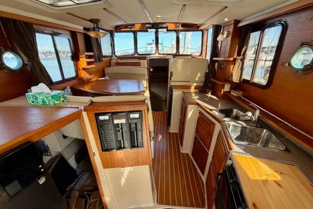  Yacht Photos Pics 2012 Ranger Tugs R-29 interior with wood finish, kitchen, and seating area.