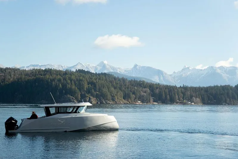  Yacht Photos Pics 2019 Jasper Marine Freedom 28 boat cruising on a serene lake with mountain backdrop.
