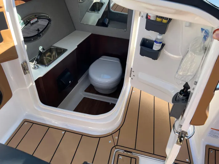  Yacht Photos Pics 2023 Chaparral 287 SSX boat interior with toilet, sink, and storage compartments.