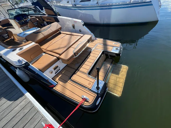  Yacht Photos Pics 2023 Chaparral 287 SSX boat with luxurious seating and swim platform at a dock.