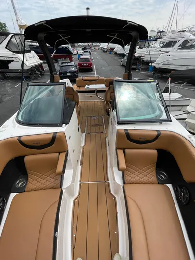  Yacht Photos Pics 2023 Chaparral 287 SSX boat with luxurious tan seating and sleek design at a marina.