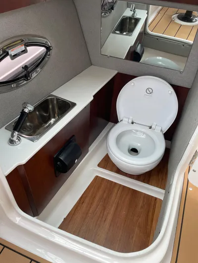  Yacht Photos Pics 2023 Chaparral 287 SSX boat bathroom with sink, toilet, and wood flooring.