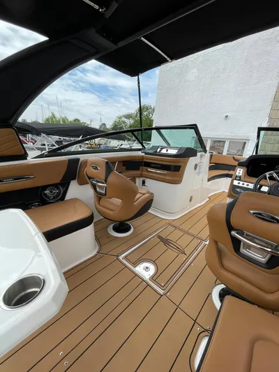  Yacht Photos Pics 2023 Chaparral 287 SSX boat interior with brown seating and modern dashboard.