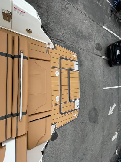  Yacht Photos Pics 2023 Chaparral 287 SSX boat with tan deck and seating, parked on concrete.