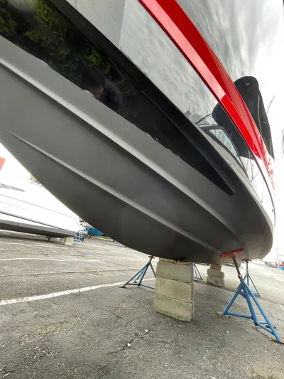  Yacht Photos Pics 2023 Chaparral 287 SSX boat hull on stands, showcasing sleek design and red accent.