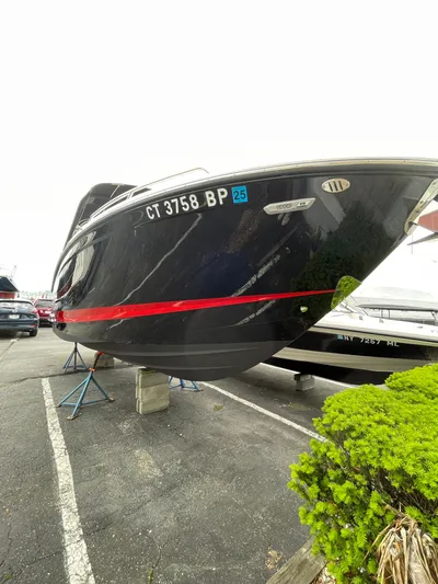  Yacht Photos Pics 2023 Chaparral 287 SSX boat on display, black hull with red stripe.