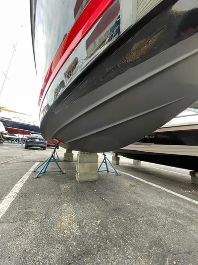  Yacht Photos Pics 2023 Chaparral 287 SSX boat on stands, showcasing sleek hull design.