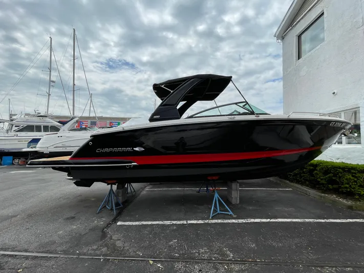  Yacht Photos Pics 2023 Chaparral 287 SSX boat on display, black with red stripe, parked outdoors.