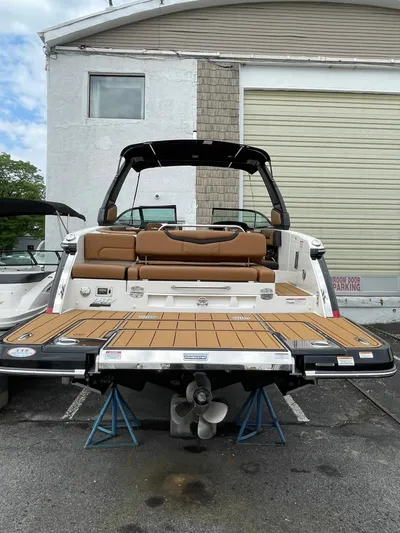  Yacht Photos Pics 2023 Chaparral 287 SSX boat with open swim platform, docked on stands.