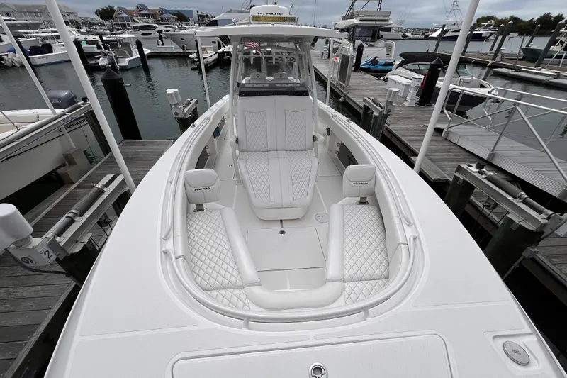  Yacht Photos Pics 2025 Fountain 34 CC boat docked, featuring luxurious white seating and sleek design.