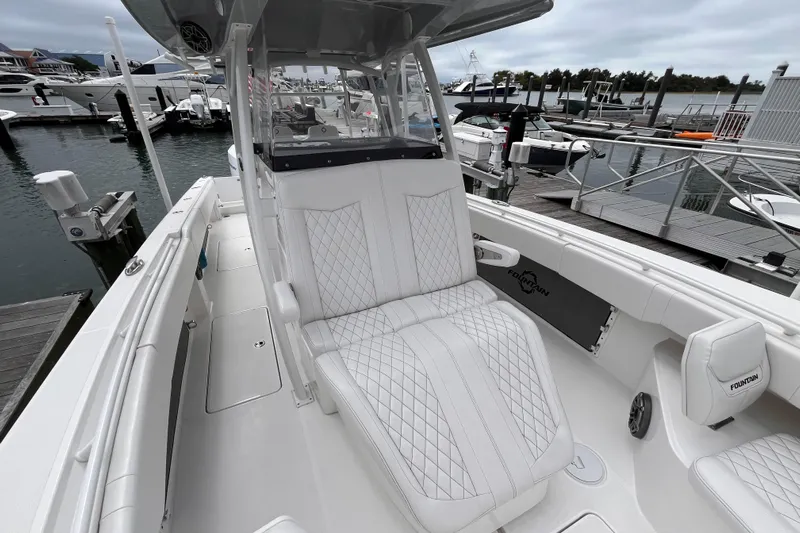  Yacht Photos Pics 2025 Fountain 34 CC boat with luxurious seating at a marina.