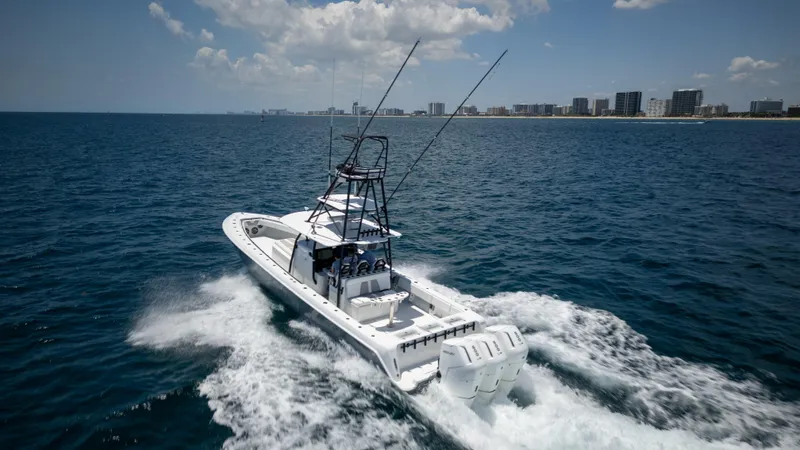 Pharma-sea Yacht Photos Pics 2023 Contender 44 CB boat cruising on open ocean near city skyline.
