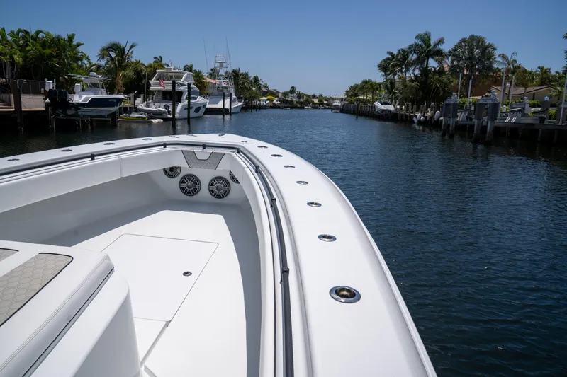 Pharma-sea Yacht Photos Pics 2023 Contender 44 CB boat cruising in a scenic canal with palm trees.