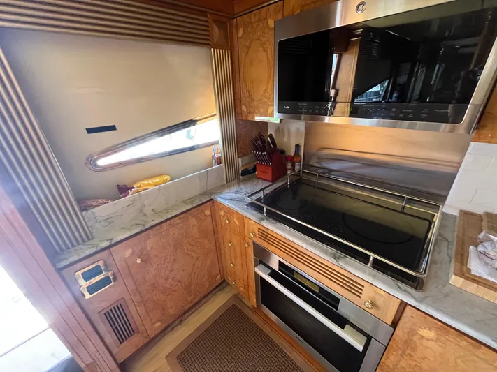 Endless Romance Yacht Photos Pics Luxurious kitchen in 2001 Astondoa 95GLX yacht with modern appliances and wood cabinetry.