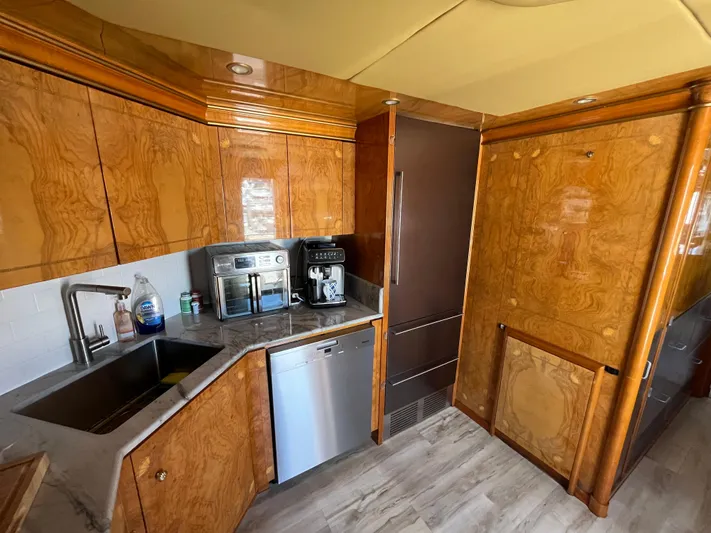 Endless Romance Yacht Photos Pics Luxurious kitchen in 2001 Astondoa 95GLX yacht with wood cabinetry and modern appliances.