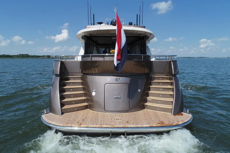  Yacht Photos Pics 2019 Van den Hoven Executive 2100 yacht cruising on open water, rear view.