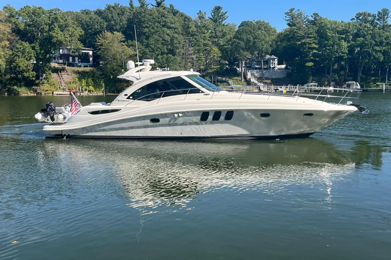  Yacht Photos Pics 2009 Sea Ray 48 Sundancer yacht on a serene lake with lush green trees.