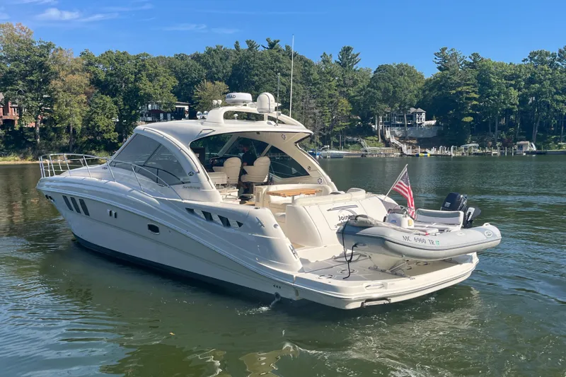  Yacht Photos Pics 2009 Sea Ray 48 Sundancer yacht on a serene lake with lush green surroundings.