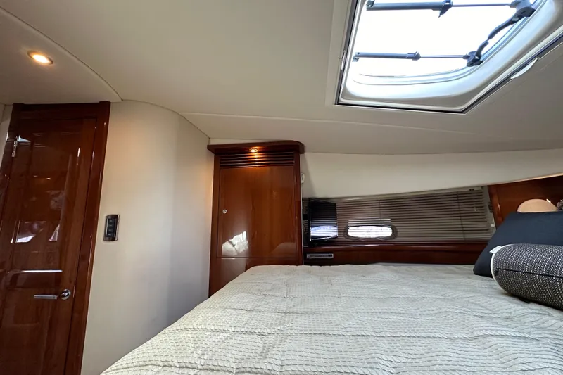  Yacht Photos Pics 2009 Sea Ray 48 Sundancer cabin interior with skylight, wooden cabinetry, and comfortable bedding.