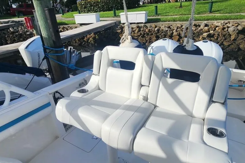 Insignia Yacht Photos Pics White seating on a 2015 Intrepid 327 Cuddy boat, docked with twin engines.