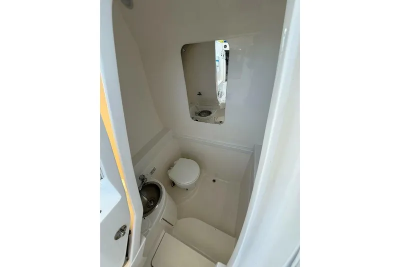 Insignia Yacht Photos Pics 2015 Intrepid 327 Cuddy boat bathroom with toilet, sink, and mirror.