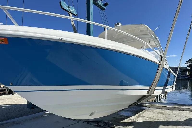 Insignia Yacht Photos Pics 2015 Intrepid 327 Cuddy boat in blue and white, docked under clear skies.