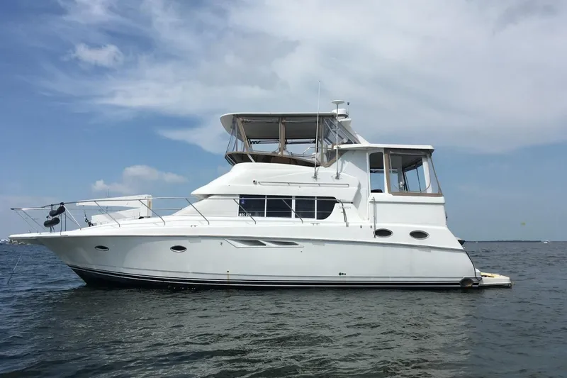 Living The Dream Yacht Photos Pics 1997 Silverton 402 Motor Yacht on calm water under a clear sky.