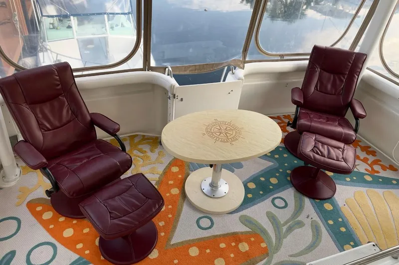 Living The Dream Yacht Photos Pics Luxurious 1997 Silverton 402 Motor Yacht interior with burgundy chairs and nautical-themed decor.