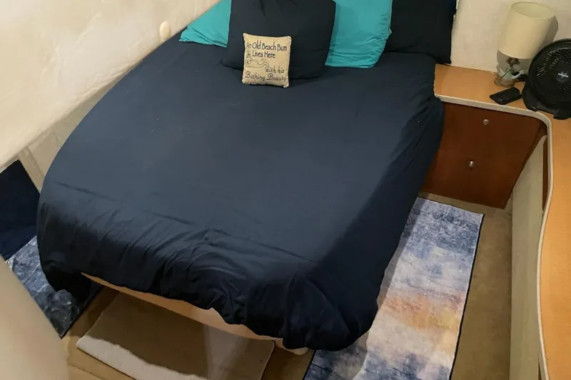 Living The Dream Yacht Photos Pics Cozy bedroom interior of 1997 Silverton 402 Motor Yacht with navy bedding and decorative pillows.