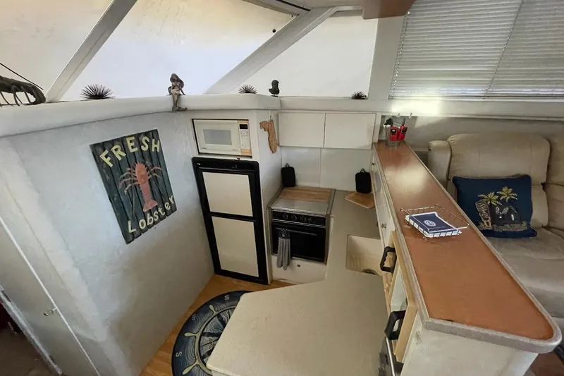 Living The Dream Yacht Photos Pics Interior of 1997 Silverton 402 Motor Yacht with kitchenette and cozy seating area.