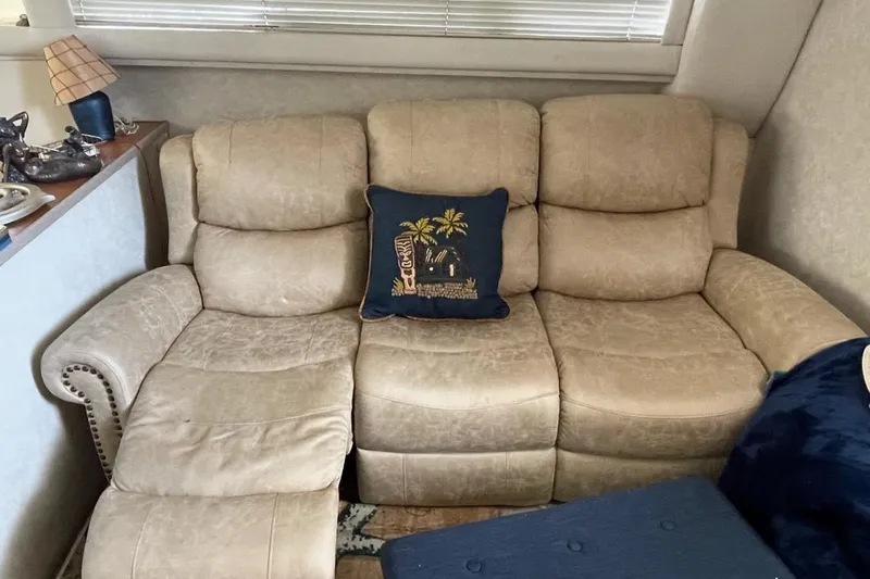 Living The Dream Yacht Photos Pics Beige leather sofa with decorative pillow inside 1997 Silverton 402 Motor Yacht cabin.