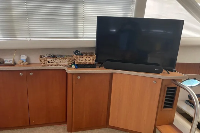 Living The Dream Yacht Photos Pics 1997 Silverton 402 Motor Yacht interior with TV, soundbar, and wooden cabinetry.