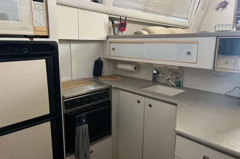 Living The Dream Yacht Photos Pics Compact kitchen in a 1997 Silverton 402 Motor Yacht with stove, microwave, and sink.