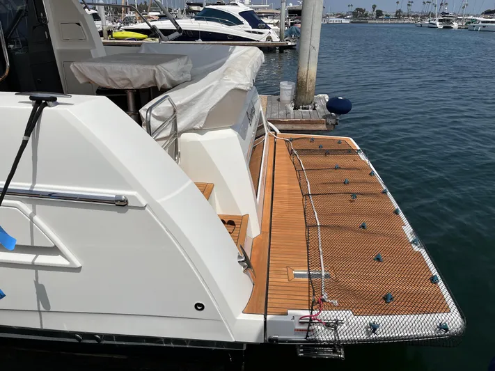 Simorgh Yacht Photos Pics Prestige 460 yacht 2019 model docked at marina with wooden deck and safety net.
