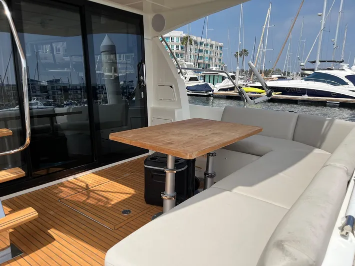 Simorgh Yacht Photos Pics Prestige 460 yacht 2019 model with outdoor seating and table in a marina.